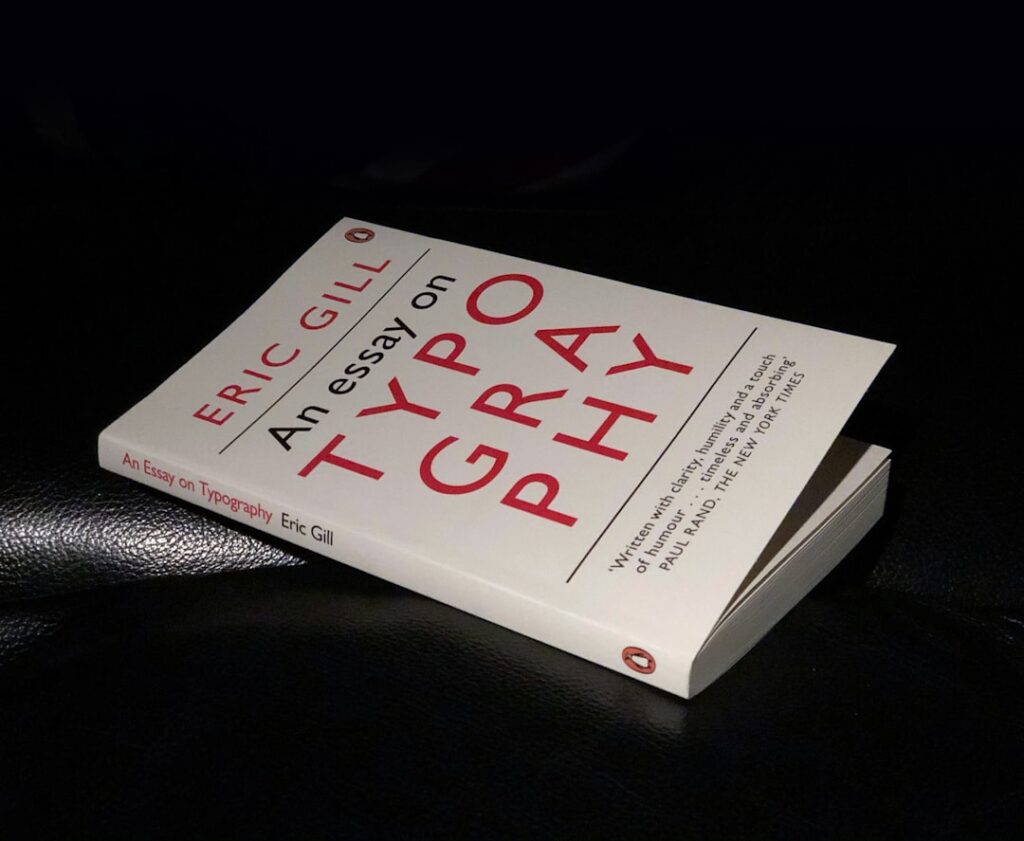 book, eric gill, close up, product shot, leather chair, black background,